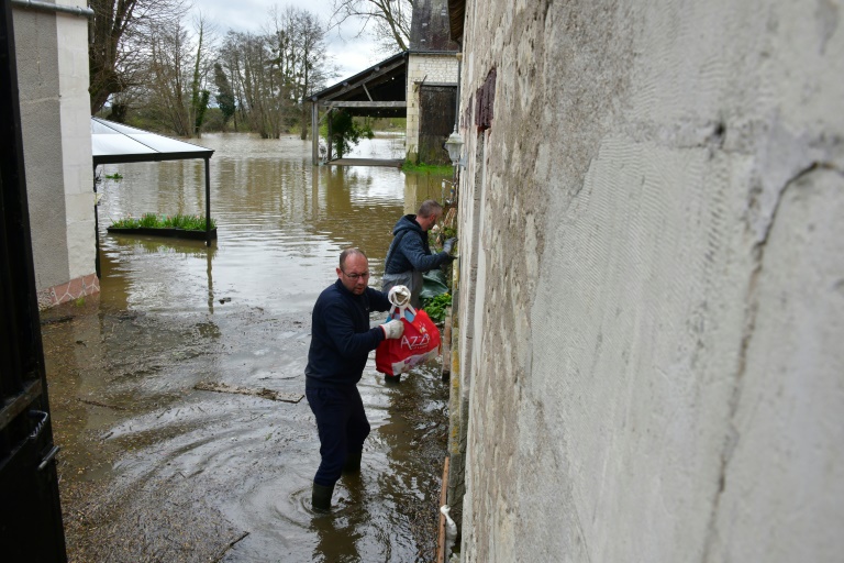 Des habitants dans une rue inondée après des crues, le 31 mars 2024 à Nouâtre, en Indre-et-Loire