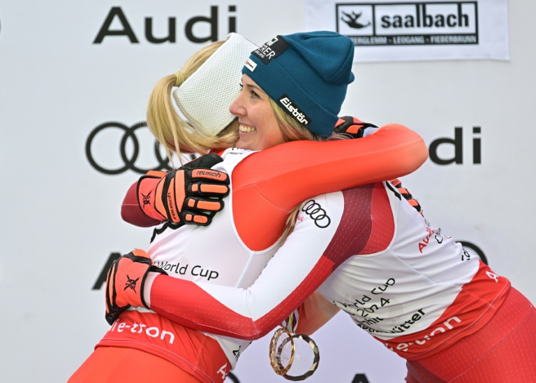 La skieuse autrichienne Cornelia Huetter (c), qui a remporté la descente de Saalbach et le globe mondial de la spécialité devant la Suissesse Lara Gut-Behrami (g), le 23 mars 2024 à Saalbach (Autriche)