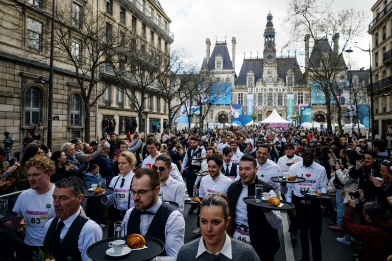 Des dizaines de serveuses et serveurs participent à la Course des garçons de café à Paris, le 24 mars 2024