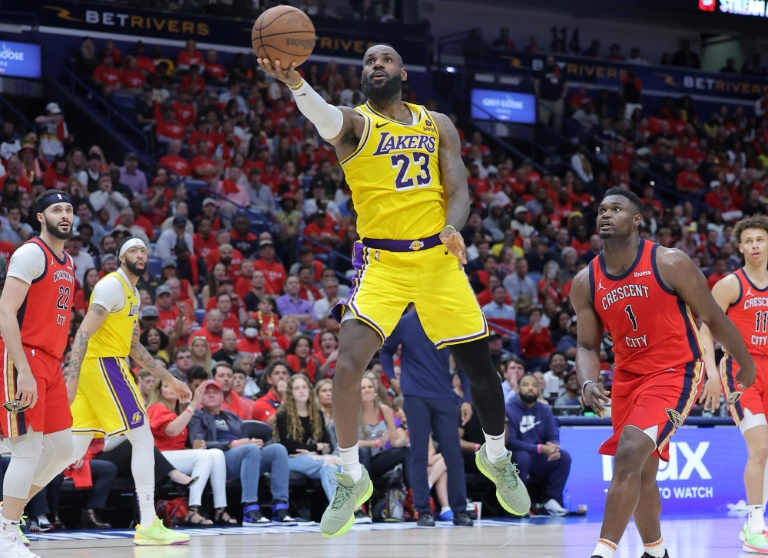 LeBron James (c.), l'ailier des Los Angeles Lakers, tire sous les yeux de Zion Williamson (d.), l'ailier fort des Pelicans de la Nouvelle-Orléans, pendant un match de play-in NBA, le 16 avril 2024, à la Nouvelle-Orléans
