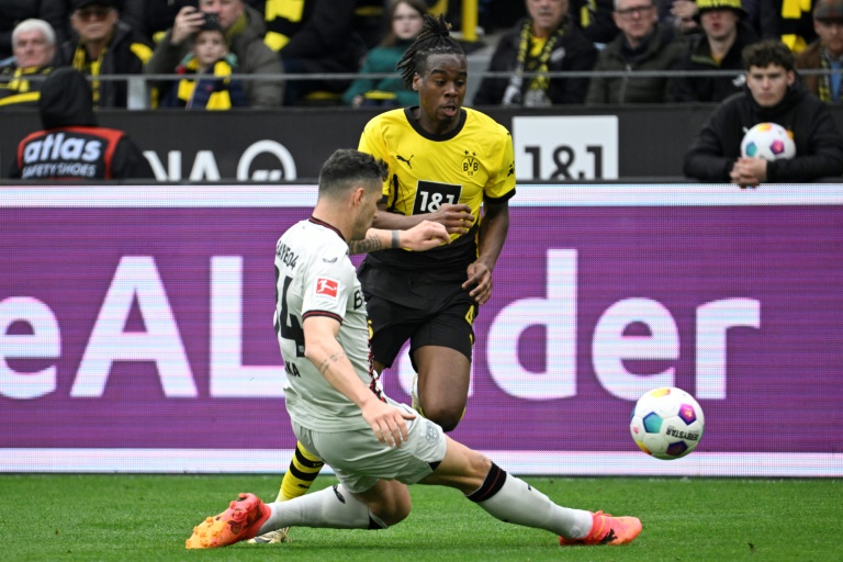 Granit Xhaka, le milieu de terrain suisse du Bayer Leverkusen, tacle le ballon devant Jamie Bynoe-Gittens, l'attaquant anglais du Borussia Dortmund, en Bundesliga le 21 avril 2024 à Dortmund