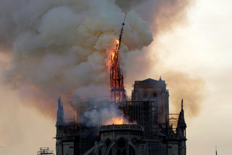 Le clocher et la flèche de la cathédrale Notre-Dame s'effondrent alors que l'édifice est en proie aux flammes dans le centre de Paris, le 15 avril 2019