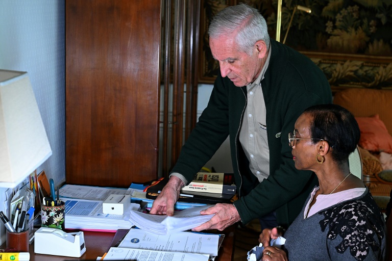 Alain Gauthier et son épouse Dafroza Mukarumongi-Gauthier, cofondateurs du Collectif des parties civiles pour le Rwanda, examinent des documents, chez eux, le 26 mars 2024 à Reims