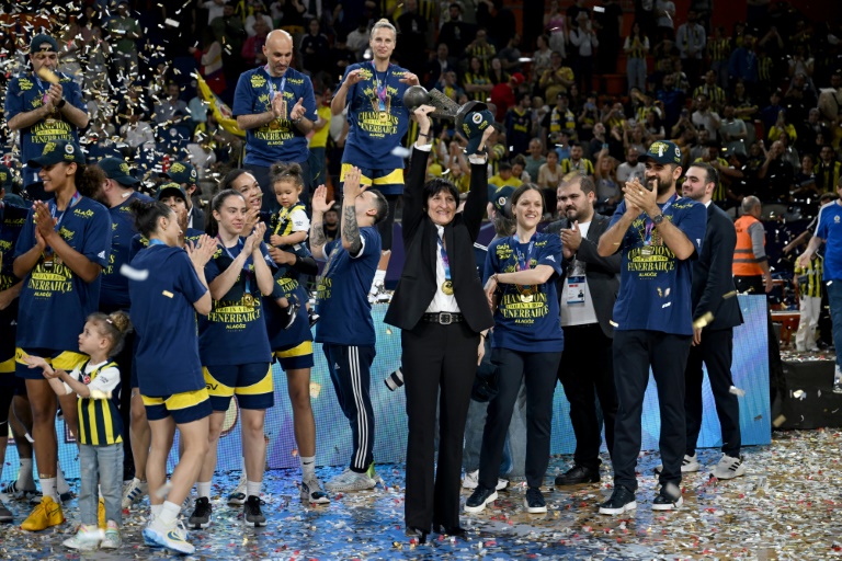 Valérie Garnier (au centre), coach de Fenerbahçe et ex-sélectionneuse de l'équipe de France de basket, brandit le trophée de l'Euroligue féminine après la victoire du club turc face à Villeneuve d'Ascq, le 14 avril 2024 à Mersin