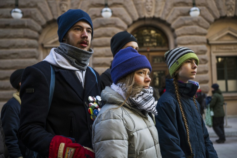 La militante climatique suédoise Greta Thunberg (C) et d'autres activistes arrivent pour bloquer les entrées du Parlement suédois lors d'une manifestation due à l'inaction des autorités suédoises, le 11 mars 2024, à Stockholm, en Suède