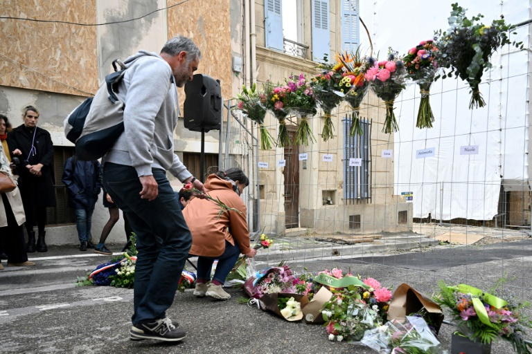 Des gens déposent des fleurs lors d'une cérémonie commémorative marquant la date anniversaire du bâtiment qui s'est effondré dans la rue Tivoli à Marseille, dans le sud de la France, le 9 avril 2024