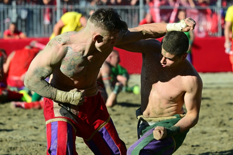 Un joueur de l'équipe rouge face à un joueur de l'équipe verte lors d'un match de calcio storico fiorentino le 11 juin 2021 à Florence