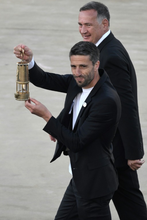 Tony Estanguet, président du comité d'organisation de Paris-2024, porte la lanterne contenant la flamme olympique, remise par la Grèce vendredi à l'occasion d'une cérémonie à Athènes