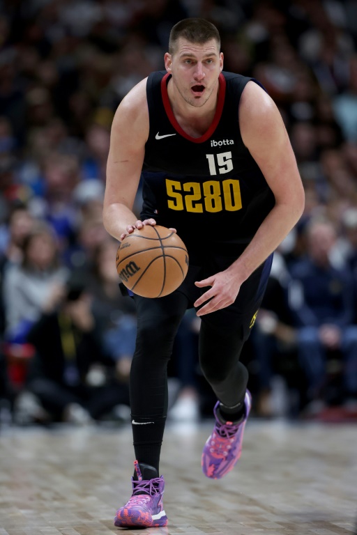 Nikola Jokic porte le ballon lors d'un match de saison régulière de NBA des Nuggets face aux Phoenix Suns, le 27 mars 2024 à Denver
