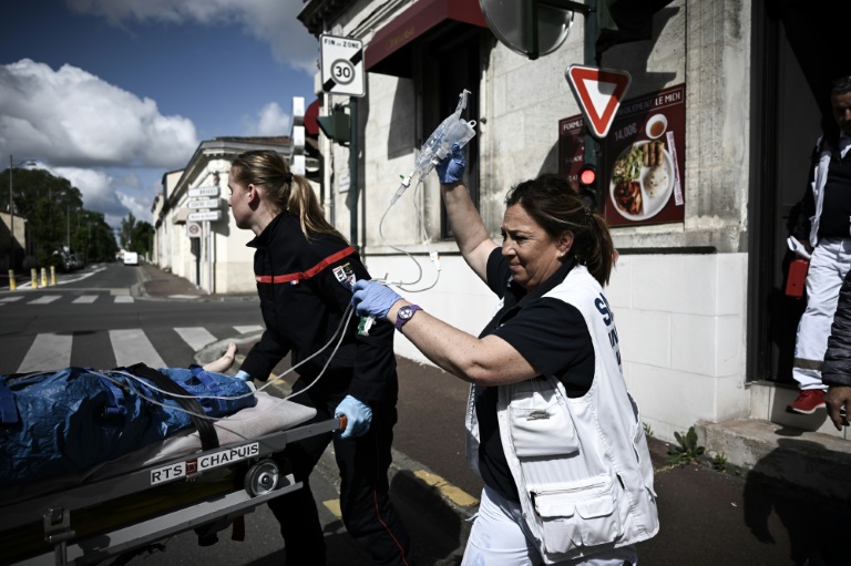 Pascale Martinet (d), infirmière anesthésiste et membre de l'une des premières unités hospitalières mobiles paramédicales (UMH-P) du CHU de Bordeaux, s'occupe d'une femme lors de son transport vers une clinique suite à un appel d'urgence, le 17 avril 2024 à Bordeaux