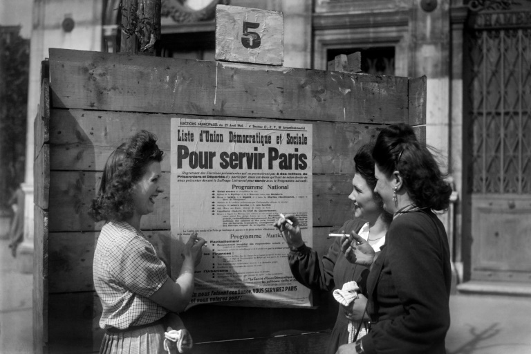 Des femmes devant une affiche électorale à Paris, le 29 avril 1945