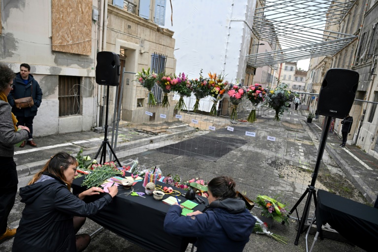 Des gens laissent des messages lors d'une cérémonie commémorative marquant le premier anniversaire de l'effondrement d'un immeuble dans la rue Tivoli à Marseille, le 9 avril 2024