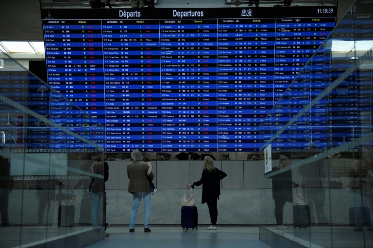 Des voyageurs consultent un tableau d' information sur les vols au départ de l'aéroport Roissy-Charles-de-Gaulle, le 16 septembre 2022