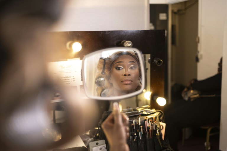 L'ancienne Miss Côte d'Ivoire France 2014 Tina Deignan se regarde dans le miroir alors qu'elle se maquille avant le concours de beauté Miss Côte d'Ivoire France à Paris, le 8 mai 2024