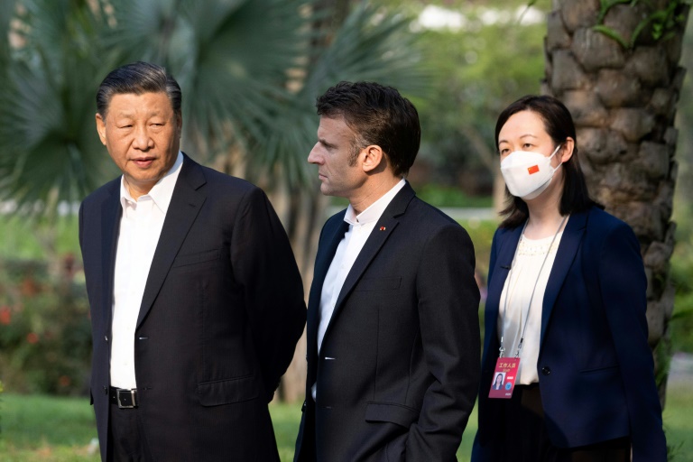 Les présidents chinois Xi Jinping et français Emmanuel Macron, accompagnés d'une interprète, le 7 avril 2023 à Canton, dans le sud de la Chine