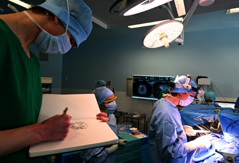 Un étudiant de l'Ecole Supérieure d'Art et de Design (Esad) dessine pendant une opération du cerveau sur un patient éveillé atteint d'une tumeur cérébrale, dans le cadre d'un programme interdisciplinaire franco-allemand en neurochirurgie, le 5 mars 2025 au CHU de Reims