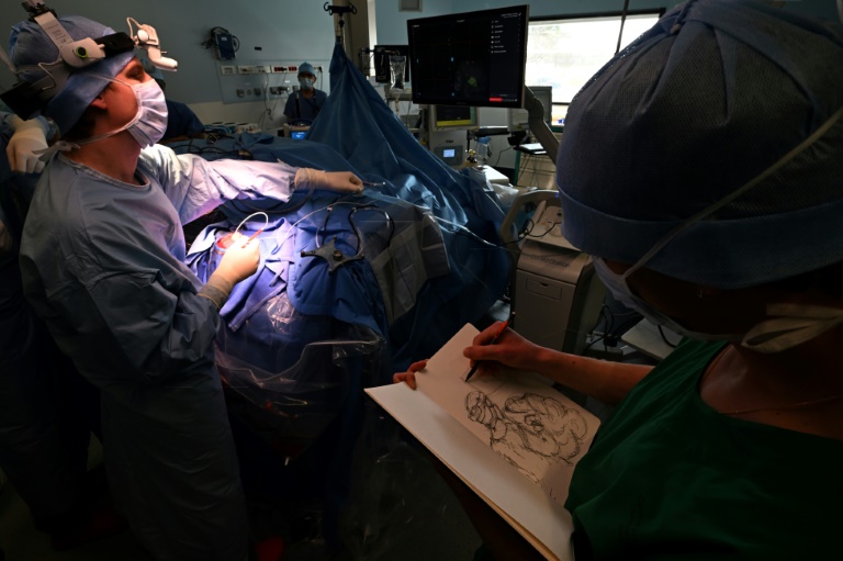 Une étudiante de l'Ecole Supérieure d'Art et de Design (Esad) dessine pendant une opération du cerveau sur un patient éveillé atteint d'une tumeur cérébrale, dans le cadre d'un programme interdisciplinaire franco-allemand en neurochirurgie, le 5 mars 2025 au CHU de Reims