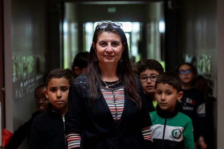 Nathalie Miguel, professeur des écoles à Colomiers, près de Toulouse, pose avec ses élèves de CE1  le 14 mars 2025