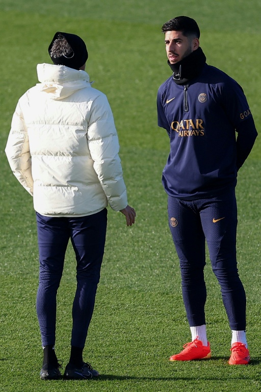 L'entraîneur espagnol du Paris Saint-Germain, Luis Enrique (g.), échange avec l'attaquant espagnol du PSG, Marco Asensio, lors d'une séance d'entraînement à Poissy, le 8 décembre 2023