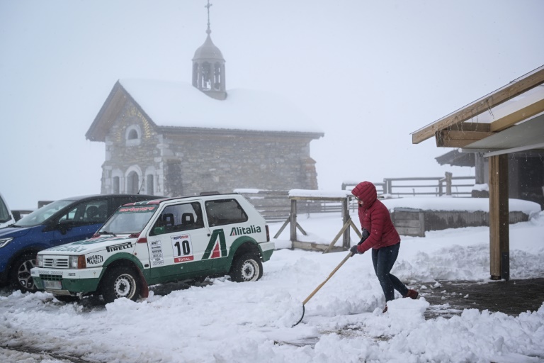 Une personne déblaie la neige au col des Aravis, près de la Clusaz, après de fortes chutes de neige, le 17 avril 2025 en Haute-Savoie