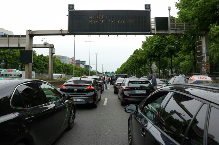 Des chaufeurs de taxis manifestent sur l'autoroute A1 près de Paris, le 21 mai 2025