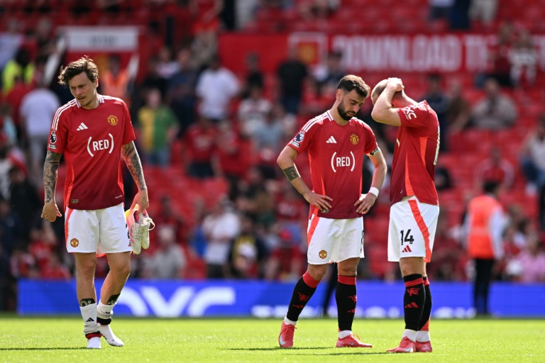 Le défenseur suédois de Manchester United Victor Lindelof (gauche), le milieu de terrain portugais Bruno Fernandes (centre), et le danois Christian Eriksen (droite) après la défaite de leur équipe face à West Ham United à Old Trafford le 11 mai 2025.