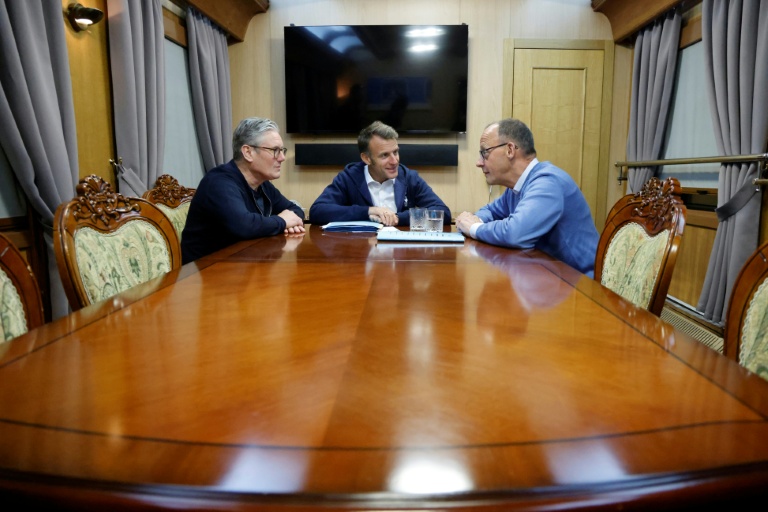Emmanuel Macron entouré de Keir Starmer (gauche) et Friedrich Merz (droite) lors d'une réunion trilatérale à bord d'un train pour l'Ukraine, le 9 mai 2025