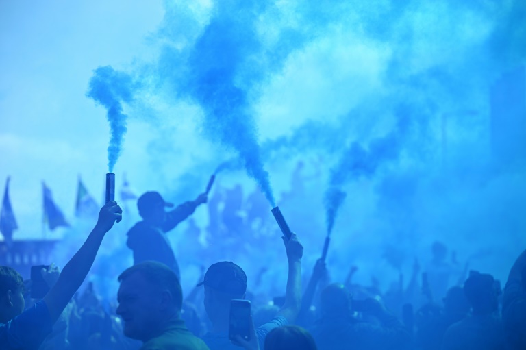 Des supporters d'Everton enveloppés par la fumée bleue des fumigènes, avant le dernier match de leur équipe à Goodison Park, le 18 mai 2025 à Liverpool