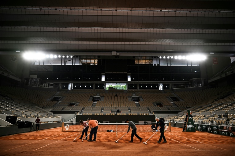 Des membres du personnel préparent la surface du court Philippe-Chatrier, avant Roland-Garros 2025, à Paris, le 21 mai 2025.
