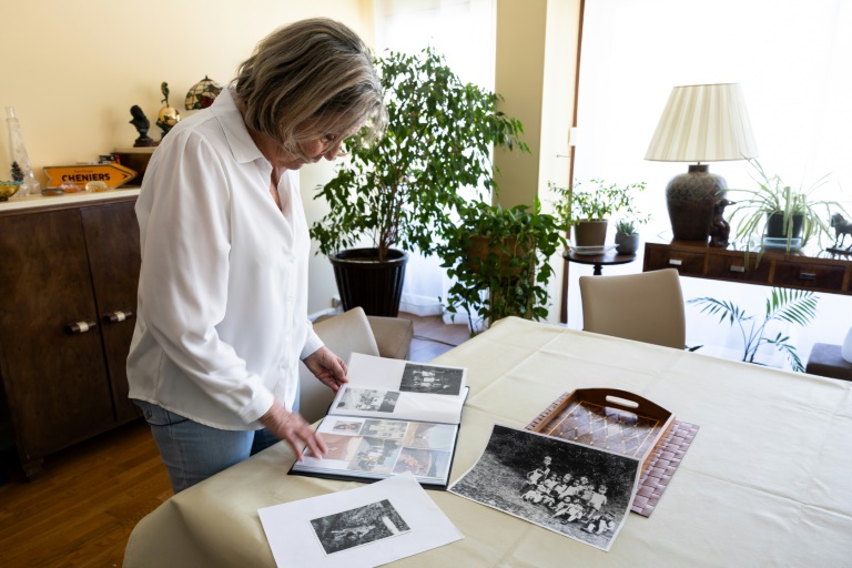 Claudine Spire regarde des photos de famille lors d'une interview à son domicile de Chaville, en région parisienne, le 9 avril 2025