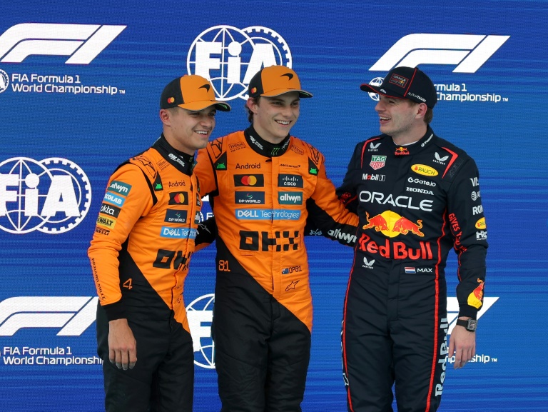 Le pilote australien de McLaren Oscar Piastri (au centre), entouré de son coéquipier britannique Lando Norris et du Néerlandais Max Verstappen (Red Bull) après les qualification du Grand Prix d'Espagne de Formule 1 sur le circuit de Catalunya à Montmelo le 31 mai 2025.