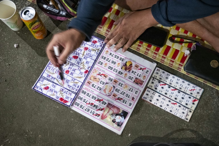 Une participante joue au bingo sur le parking d'un centre commercial désaffecté, dans le quartier de Rivière-Salée à Nouméa, en Nouvelle-Calédonie, le 8 mai 2025