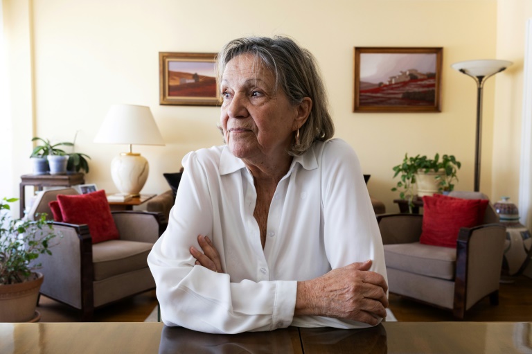 Claudine Spire regarde une photo de son enfance lors d'une interview à son domicile de Chaville, en région parisienne, le 9 avril 2025