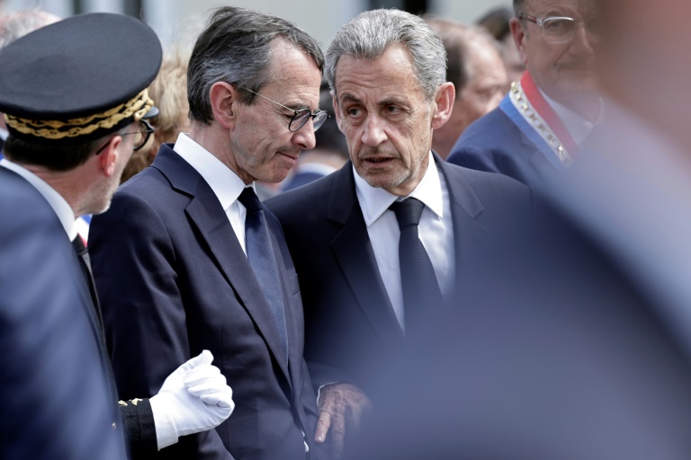 L'ancien président Nicolas Sarkozy (C) discute avec le ministre de l'Intérieur Bruno Retailleau (2e G) lors d'un hommage à Aurélie Fouquet, policière municipale tuée en 2010, le 20 mai 2025 à Villiers-sur-Marne, dans le Val-de-Marne