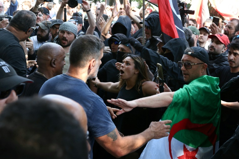 Un membre du personnel de sécurité du Parti socialiste (PS) (g) se heurte aux manifestants et aux militants antifascistes de gauche (antifa) lors d'un rassemblement marquant la Journée internationale des travailleurs, le 1er mai 2025 à Paris