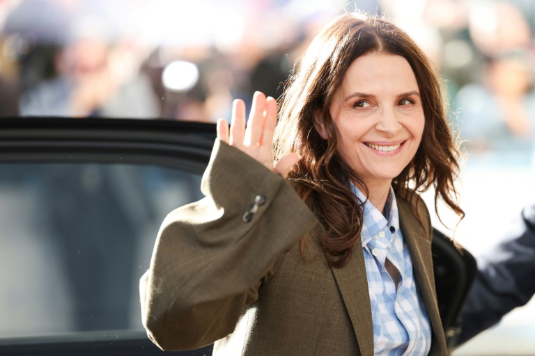 L'actrice française et présidente du jury du 78e festival de Cannes Juliette Binoche fait un geste à son arrivée pour un dîner avec les membres du jury à Cannes, dans le sud de la France, le 12 mai 2025