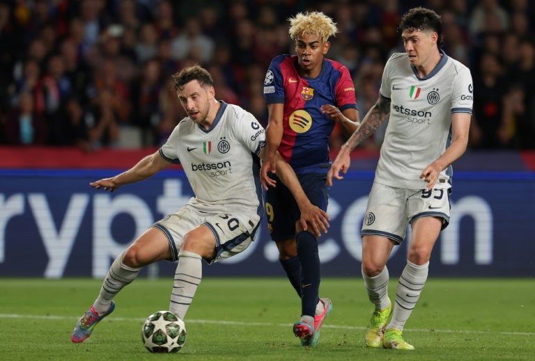Lamine Yamal entre deux défenseurs de l'Inter Milan, le Brésilien Carlos Augusto (G) et l'Italien Alessandro Bastoni (D), lors de la demi-finale aller de Ligue des champions, le 30 avril 2025 à Montjuic