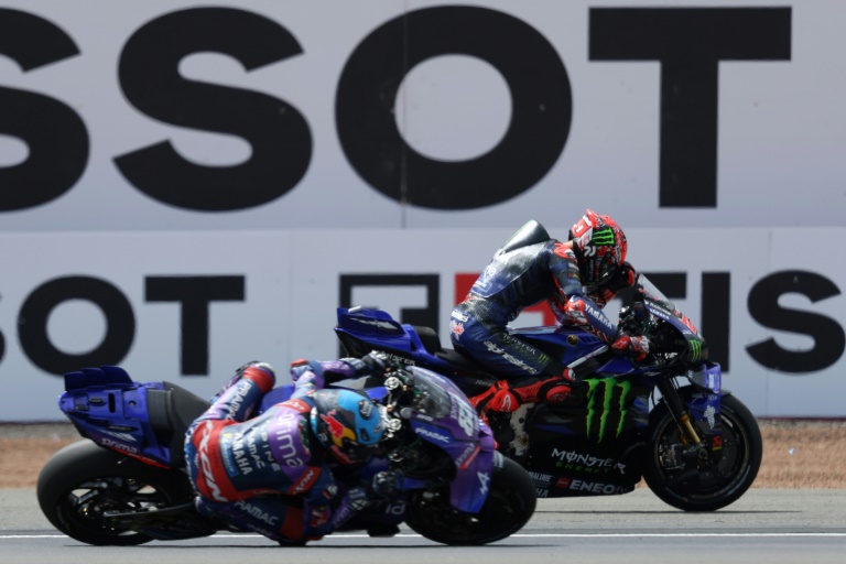 Le pilote Monster-Yamaha Fabio Quartararo (à l'arrière plan) abandonne sur problème technique alors qu'il était en tête de près de 5 secondes au GP moto de Grande Bretagne à Silverstone le 25 mai 2025
