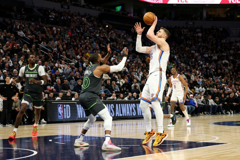 Isaiah Hartenstein (d.), le pivot du Thunder d'Oklahoma City, tire devant Mike Conley, le meneur des Timberwolves du Minnesota, lors d'un match de saison régulière de NBA, à Minneapolis, le 23 février 2025