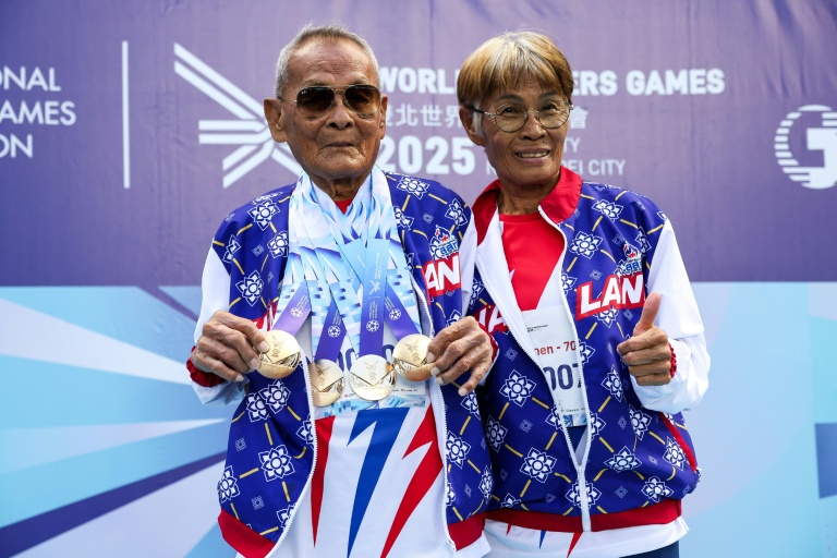 Le Thaïlandais Sawang Janpram, le concurrent le plus âgé des World Masters Games 2025 (105 ans), prend des photos avec sa fille Siripan Janpram (à droite) après avoir remporté la médaille d'or du lancer du poids masculin dans la catégorie des 100 ans et plus, à Taipei, le 22 mai 2025