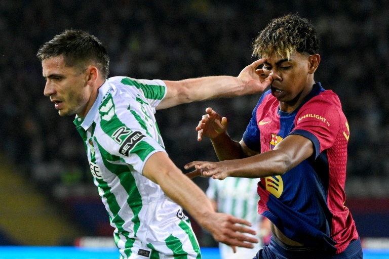 Le défenseur français du Betis Séville Romain Perraud (g.) et l'attaquant espagnol de Barcelone Lamine Yamal se disputent le ballon lors d'un match de Liga, à Barcelone, le 5 avril 2025