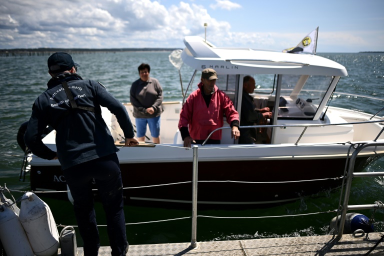 Des agents de la police de l'environnement de l'OFB transmettent des consignes de prévention aux plaisanciers pour les empêcher de mouiller dans les zones réglementées où l'habitat aquatique des zostères est surveillé et développé pour lutter contre l'érosion et l'ensablement, du Bassin d'Arcachon, le 13 mai 2025 en Gironde