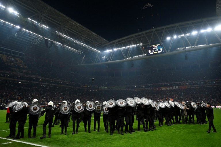 Des policiers anti-émeutes turcs se protègent derrière leurs boucliers lors du match de Super Lig entre Galatasaray et Fenerbahce au stade Ali Samiyen Sport Complex à Istanbul le 24 février 2025.