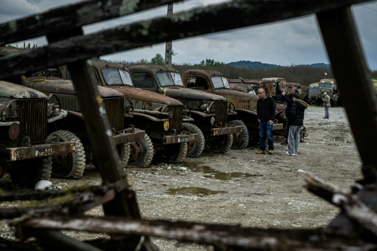 Des visiteurs se promènent parmi des épaves de véhicules militaires de la Seconde Guerre mondiale exposées à La Sône, le 8 mai 2025 en Isère