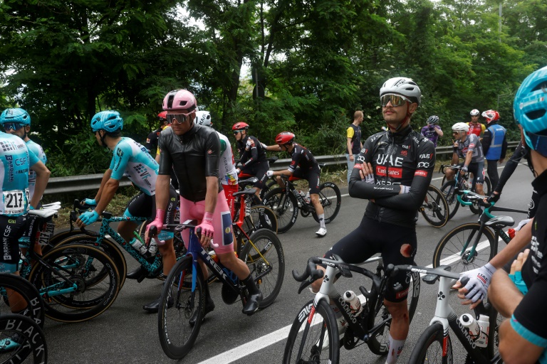 Les coureurs attendent de repartir après l'interruption du Tour d'Italie cycliste à la suite d'une série de chutes lors de la 6e étape entre Potenza et Naples le 15 mai 2025.