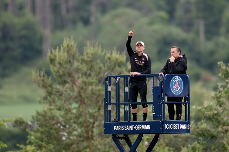 L'entraîneur espagnol du Paris Saint-Germain, Luis Enrique (g.), dirige une séance depuis une plate-forme à côté du psychologue du club, Joaquin Valdes Fonseca (d.), au centre d'entraînement du club à Poissy, le 21 mai 2025
