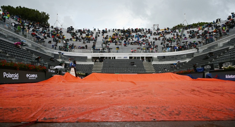Des spectateurs sous des parapluies pendant l'interruption du tournoi de Rome à cause de la pluie le 13 mai 2025