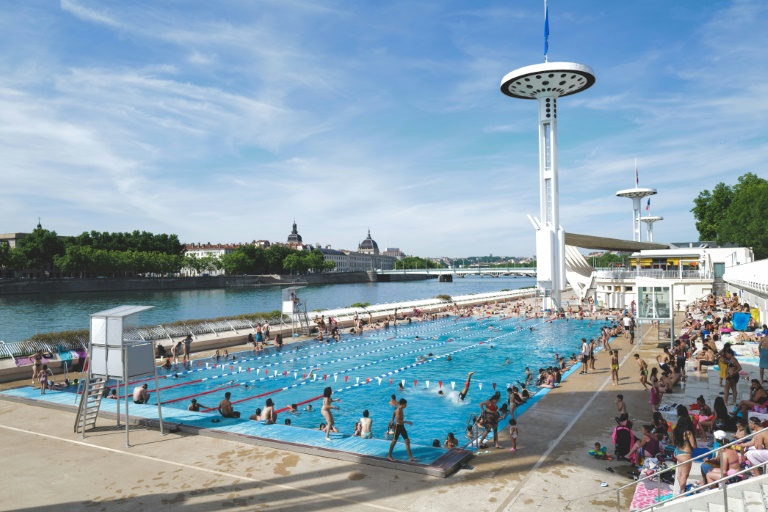 Des personnes profitent d'une piscine en plein air lors d'une vague de chaleur à Lyon, le 18 mai 2022 dans le Rhône