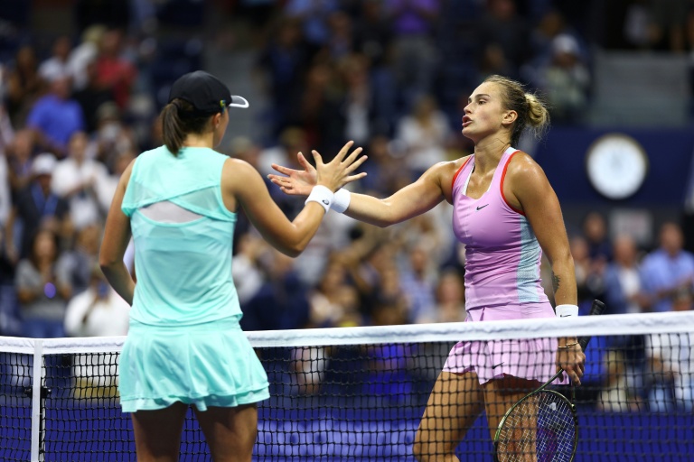 La Polonaise Iga Swiatek (g.) serre la main de la Bélarusse Aryna Sabalenka après avoir remporté la demi-finale de l'US Open 2022, à New York, le 8 septembre 2022