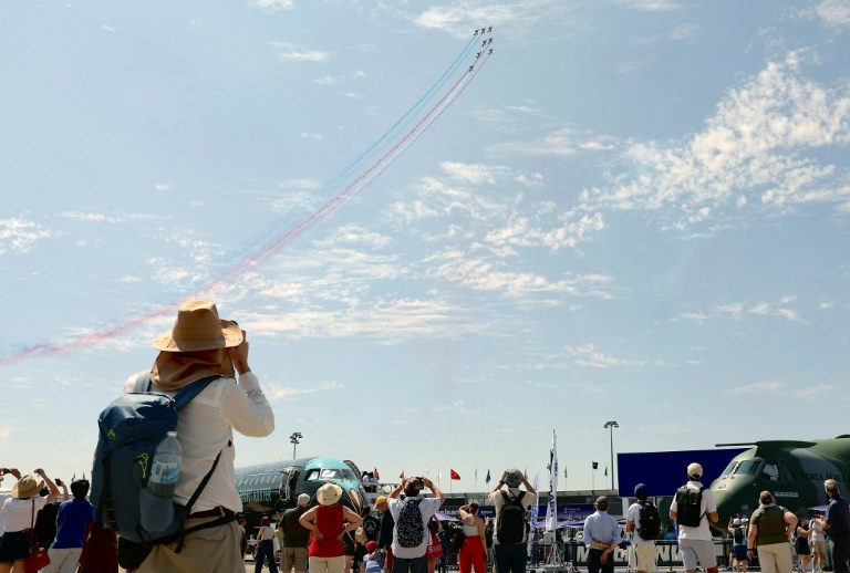 Des visiteurs regardent des avions de la patrouille de France pendant la 55e édition du Salon international de l'aéronautique et de l'espace à l'aéroport du Bourget, au nord de Paris, le 20 juin 2025